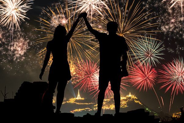 Sillouette of two people holding hands with fireworks in the background. (Photo: Dreamstime)