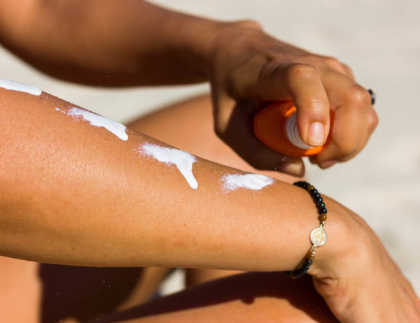 Person squirting suncreen on their arm. (Photo: Getty Images)