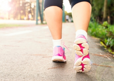 A woman's feet in pink sneakers running away from the camera. (Photo: Daniel Reche/Pexels)