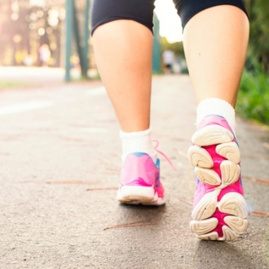 A woman's feet in pink sneakers running away from the camera. (Photo: Daniel Reche/Pexels)