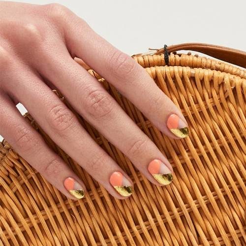 Woman's hand with peach beds and gold tips. (Photo: Paintbox)