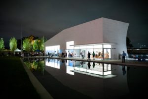 Outside of The Reach at night reflected in plaza on the new fountain with people inside. (Photo: Nicholas Karlin Photography)
