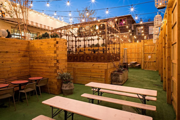 The back courtyard at Calico that is fenced with picnic tables, artificial grass and tables with chairs. (Photo: Calico)