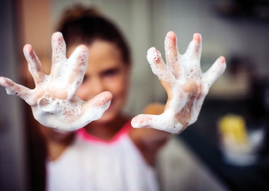 Little girl holding up her soapy hands. (Photo: Getty Images)