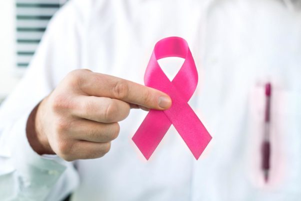 Doctor holding pink breast cancer awareness ribbon. (Photo: iStock)