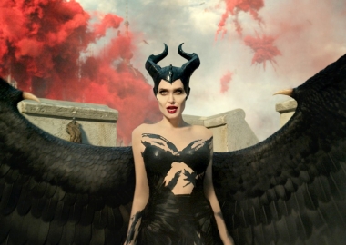 Angelina Jolie dressed as Maleficent with red smoke in the background. (Photo: Walt Disney Studios)