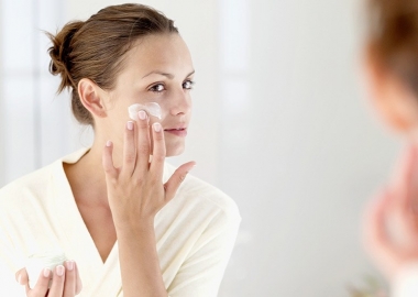 Woman applying moisturizer to her face. (Photo: Stockbyte)