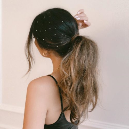 Woman with brown hair pulled back in a pony tail and pearl accents in her hair. (Photo: Justine Marjan/Instagram)