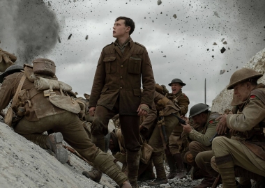 Lance Corporal Schofield (George MacKay) stand in the middle of battle. (Photo: Universal Pictures)