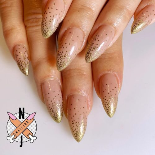 Woman with gradient gold glitter on her nails, heavy on the tips then lighter at the beds. (Photo: Nails by Fariha Ali/Instagram)