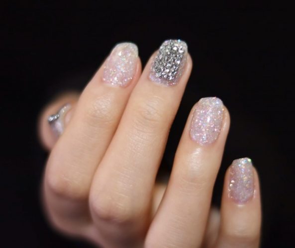 Woman with thumb & middle finger in silver glitter and the rest in clear glitter. (Photo: Unistella/Instagram)
