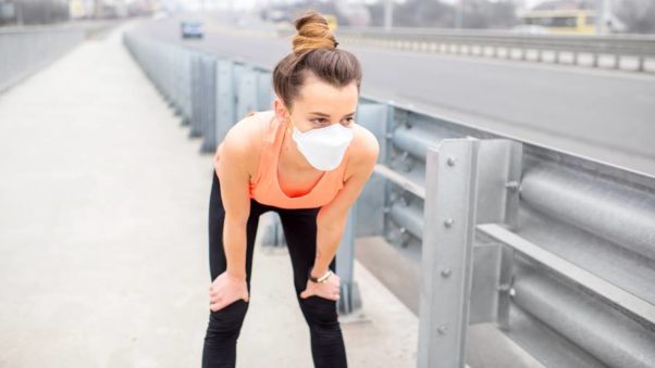 Woman taking a break from jogging with a mask over her face. (Photo: 123RF)