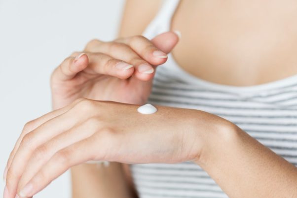 Closeup of woman applying lotion to her hand. (Photo: Rawpixel/Pexels)