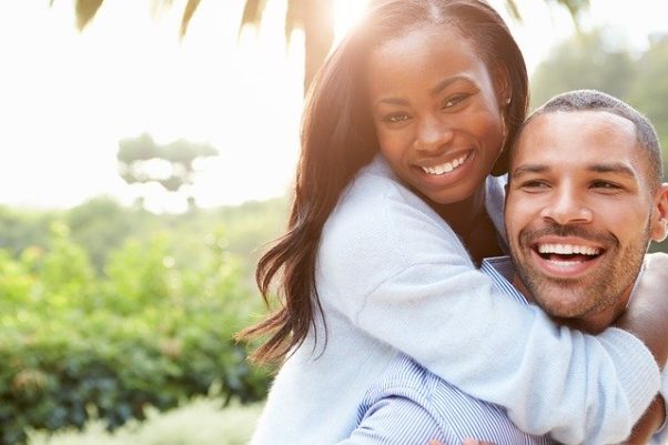 Black couple with him carrying her on his back, both smiling. (Photo: Free-Photos/Pixabay)
