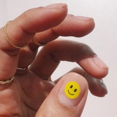 A woman's hand with a happy face on her thumb nail. (Photo: Hang Nguyen/Instagram)