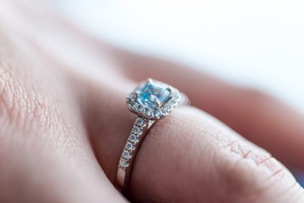 A woman's hand with a square aquamarine ring on it. (Photo: Andy Holms/Unsplash)