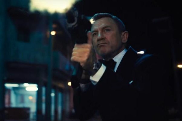 James Bond (Daniel Craig) dressed in a tux firing an automatic rifle. (Photo: Universal Pictures)