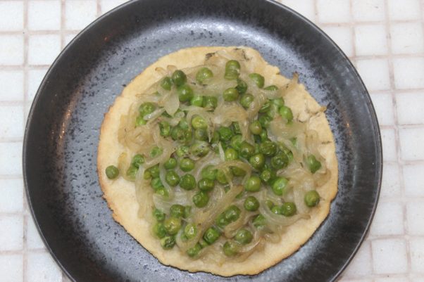 Xiquet's coques caseres with tomacat sauce, green peas and caramelized onions on flatbread on a black plate. (Photo: Mark Heckathorn/DC on Heels)