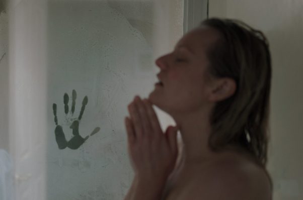 A handprint in the steam on the door as Cecilia Kass (Elisabeth Moss) takes a hot shower. (Photo: Univesal Pictures)