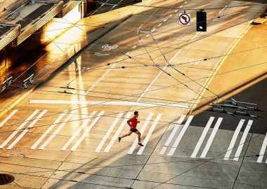 A lone runner crossing a deserted street. (Photo: Getty Images)