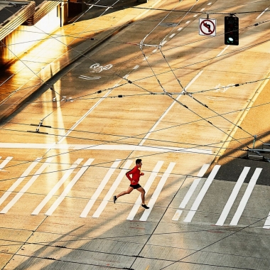 A lone runner crossing a deserted street. (Photo: Getty Images)