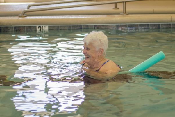An older, gray haired woman swimming in a pool with a pool noodle. (Photo: VLPRA)