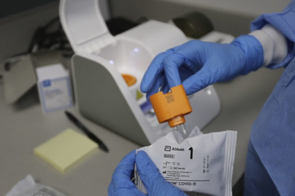 In a frame grab from video, a lab technician prepares the Abbott Laboratories ID Now testing machine at Detroit Health Center, Friday, April 10, 2020, in Detroit. (Photo: Carlos Osorio/AP)