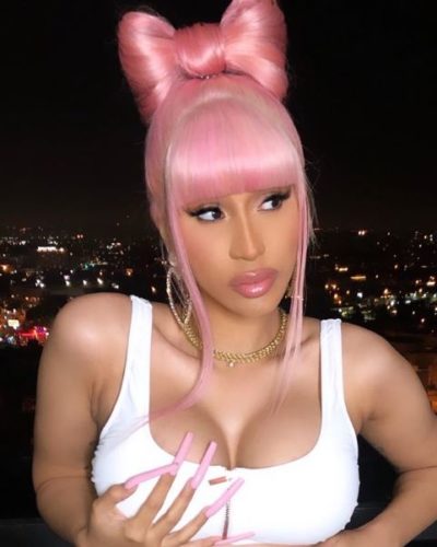 Cardi B with pink hair tied in a bow on top of her head and matchig pink lips and nails. (Photo: Cardi B/Instagram)