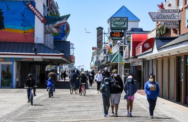 People walk on the Ocean City boardwalk in coats and face masks on May 9, 2020. (Photo: Jonathan Newton/Washington Post)