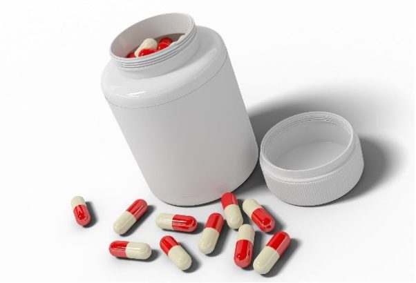 A white pill bottle with red and white capsules laying on a counter. (Photo: Contributed)