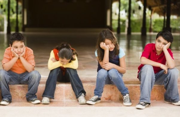 Four bored kids sitting beside each other. (Photo: Great Schools)