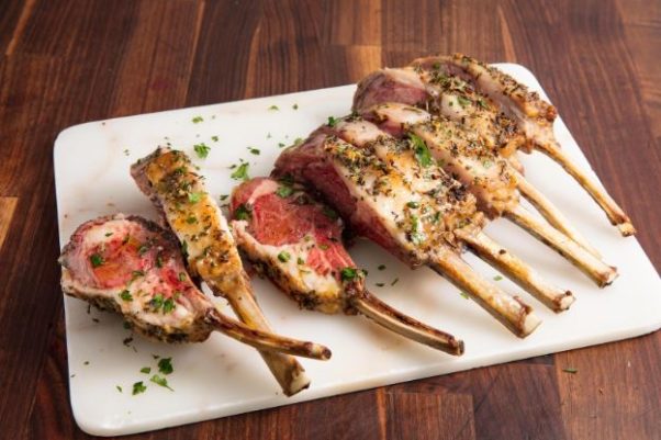 Rack of lamb chops on a white service platter. (Photo: Ethan Calabrese)