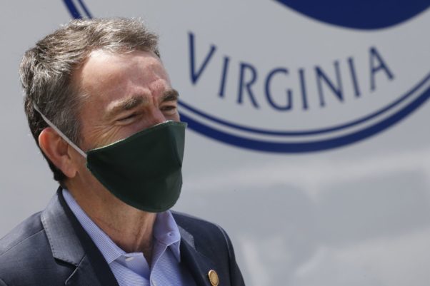 Virginia Gov. Ralph Northam listens as he prepares to speak to a group of volunteers to distribute supplies at health equity community event Tuesday May 12, 2020, in Richmond, Va. (Photo: /Steve Helber)