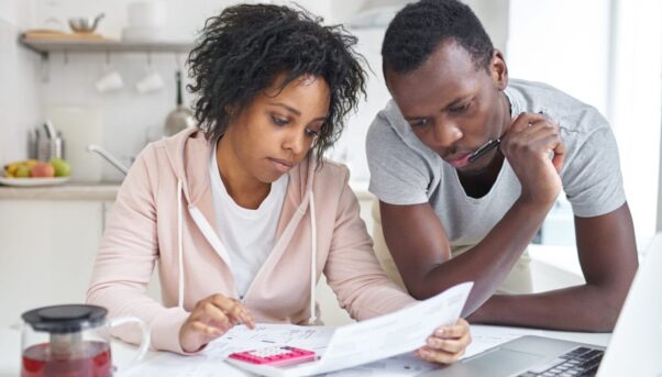 A young black couple work on a family budget. (Photo: Shutterstock)