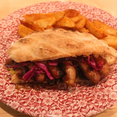 Ambar's smoked grilled sausage sandwich is on a red and white plate with house-cut fries. (Photo: Mark Heckathorn/DC on Heels)