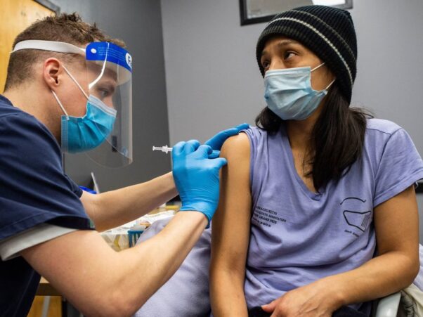 A Latina woman is vaccinated with the Pfizer-BioNTech Covid-19 vaccine by a male doctor in Chelsea, Mass., on Feb. 16, 2021. (Photo: Joseph Prezioso/AFP via Getty Images))
