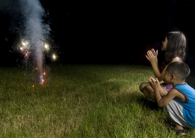 Two children squatting down watching sparks shoot into the sky from fireworks. (Photo: Two children squatting down watching sparks shoot into the sky from fireworks. (Photo: Shutterstock)Shutterstock)