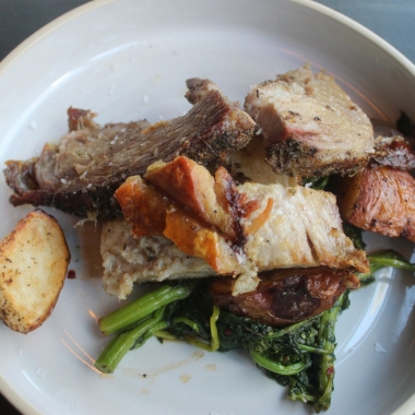 Porchetta roast with roasted red potatoes and spicy broccoli rabe on a white plate. (Photo: Mark Heckathorn/DC on Heels)