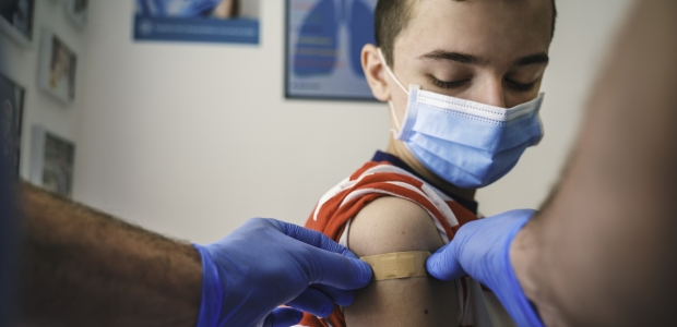 A young boy gets a bandage put on his arm after getting his COVID-19 vaccine. (Photo: Getty Images)