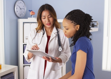 A young black woman in a female doctor's office. (Photo: USC)