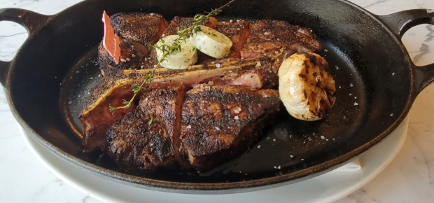 The 36-ounce, 28-day dry aged prime porterhouse steak for two with roasted garlic and maître de butter for $110. (Photo: Mark Heckathorn/DC on Heels)
