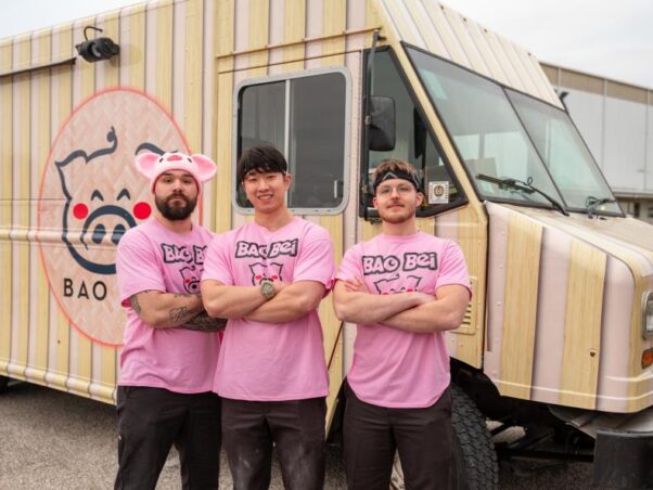 Zakary Keres, owner Kevin Hsieh and Cody Hoover in front of their food truck on Food Network's The Great Food Truck Race. (Photo: Robert Gomez/Food Network)