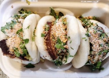 Three pork belly buns in a cardboard take out box. (Photo: Bao Bei)