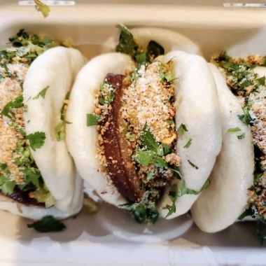 Three pork belly buns in a cardboard take out box. (Photo: Bao Bei)