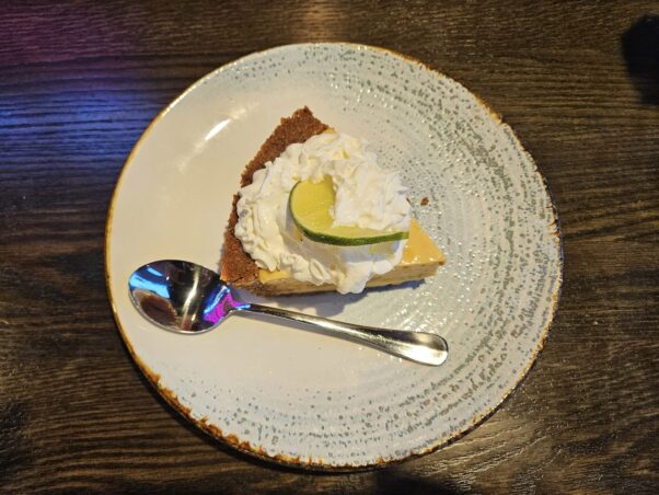 A slice of key lime pie and a spoon on a round white plate. (Photo: Nick Bullock/DC on Heels)