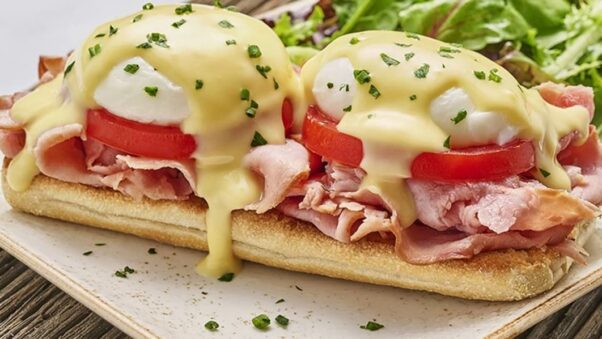 First Watch's classic Benedict with two poached cage-free eggs atop toasted ciabatta piled high with smoked ham and vine-ripened tomato and covered with hollandaise. Served with lemon-dressed organic mixed greens. (Photo: First Watch)