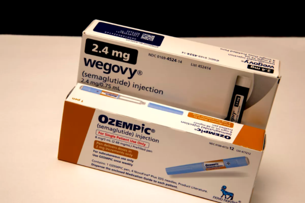 A blue and white box of Wegovy sitting on a counter behind an orange and white box of Ozempic on a white counter. (Photo: Michael Siluk/Getty Images)