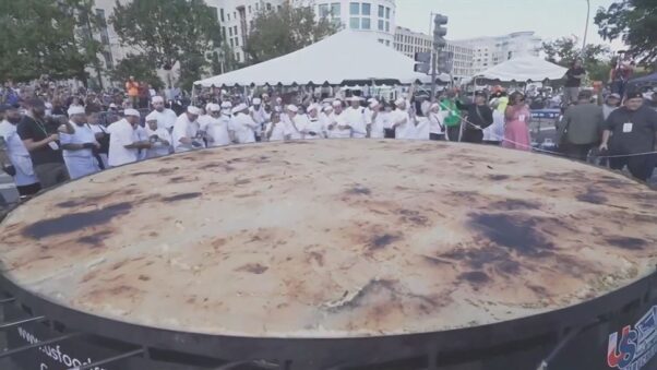Chefs pose behind the World's Largest Pupusa at Fiesta DC on Saturday as a representative from Guinness World Records measures it. (Photo: WRC)