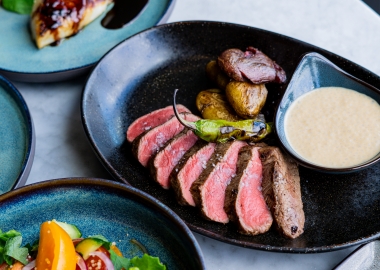 The Wren's new grilled angus beef tenderloin with smashed fingerling potatoes and wagyu demi espuma on a black plate. (Photo: Wren)