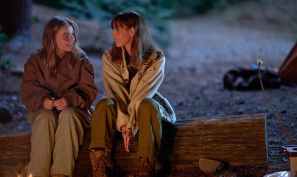 Aubrey Plaza (left) and Maisy Stella sitting on a log in the woods at night in <em>My Old Ass</em>. (Photo: Shane Mahood/Amazon MGM Studios)